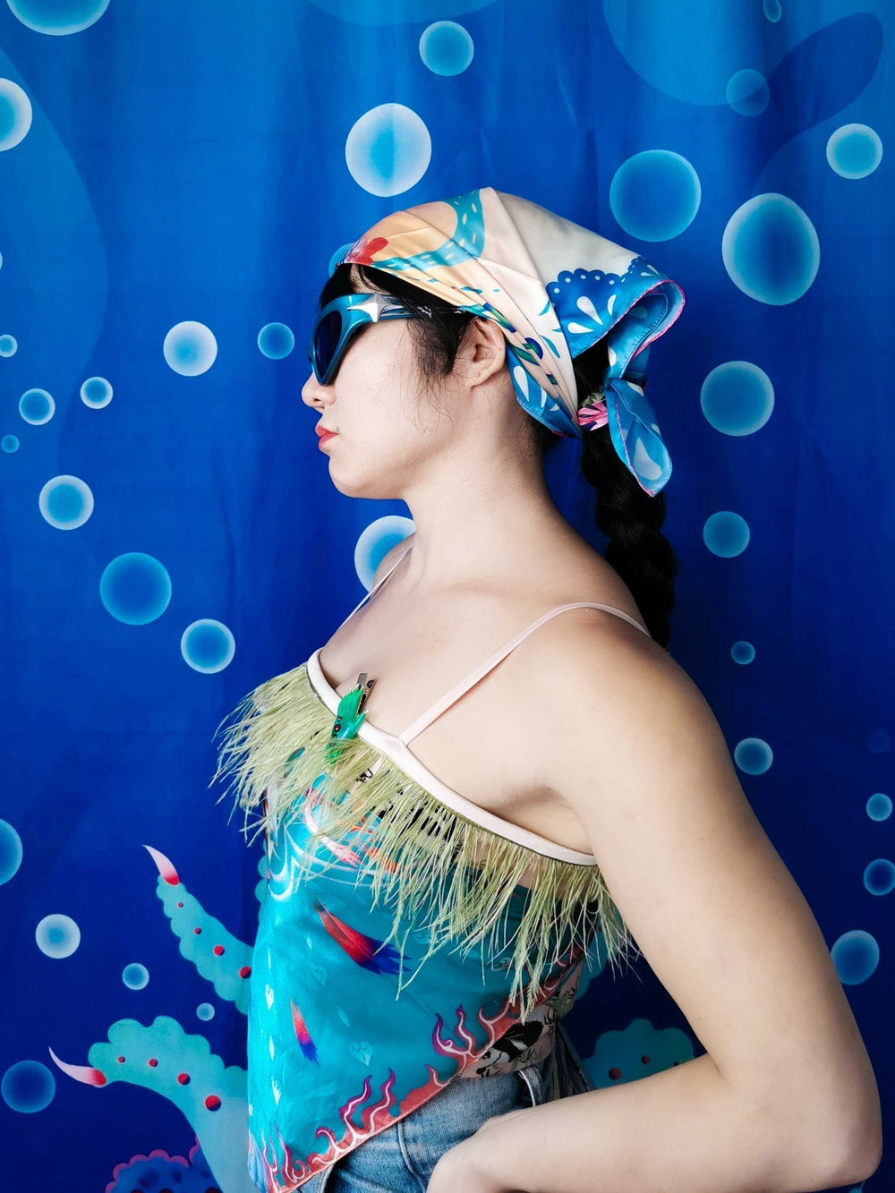 Hand-painted scarf used as a headwrap, featuring unique double-sided triangular design and vibrant colors.