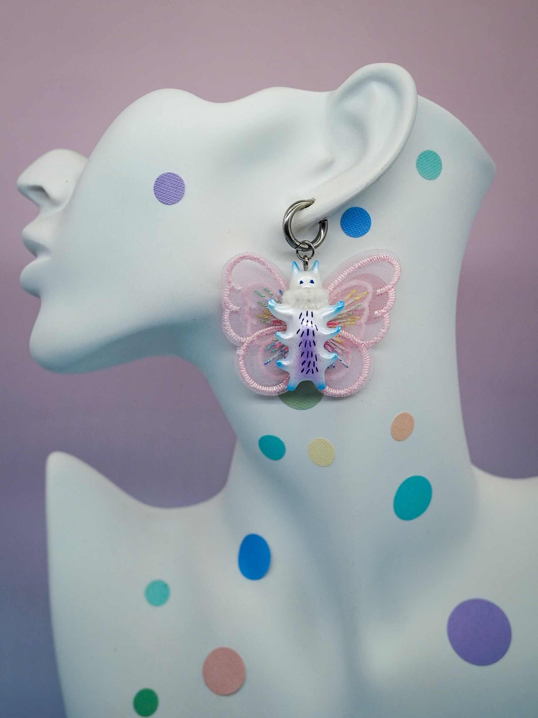 Butterfly cat earring with pink wings and purple details.