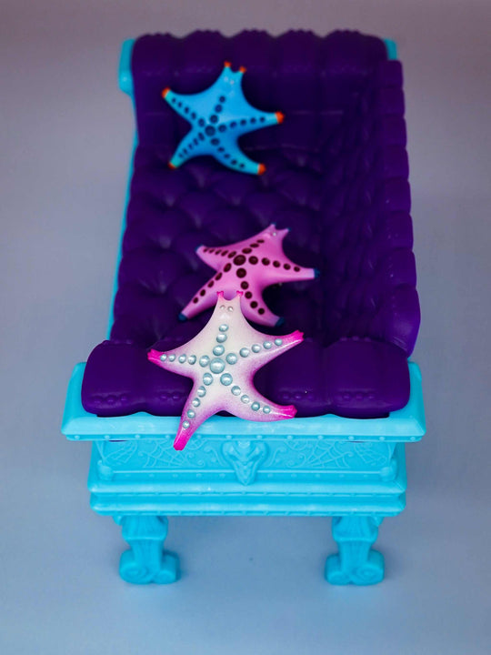 SeaStar cat hairclip and brooch in pearl, pink, and magenta on a blue and purple display.