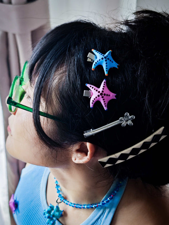 SeaStar cat hairclip and brooch in vibrant lake blue and orange, worn in hair.