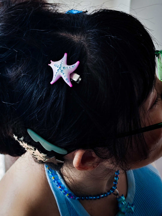 SeaStar cat hairclip in pearl color blocking and pink worn on dark hair.