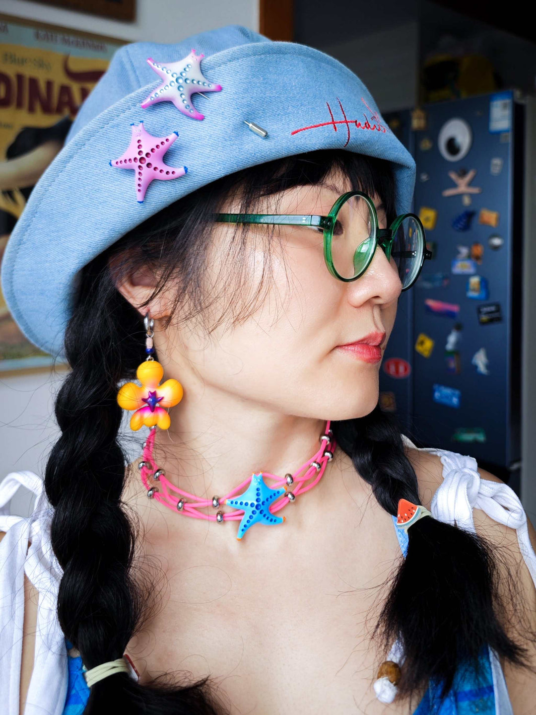 SeaStar cat-shaped hairclip and brooch in pearl color blocking and pink, modeled on a woman with braids and colorful accessories.