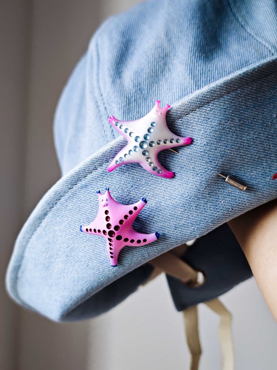 SeaStar cat hairclip and brooch in pearl color blocking and pink on denim fabric.
