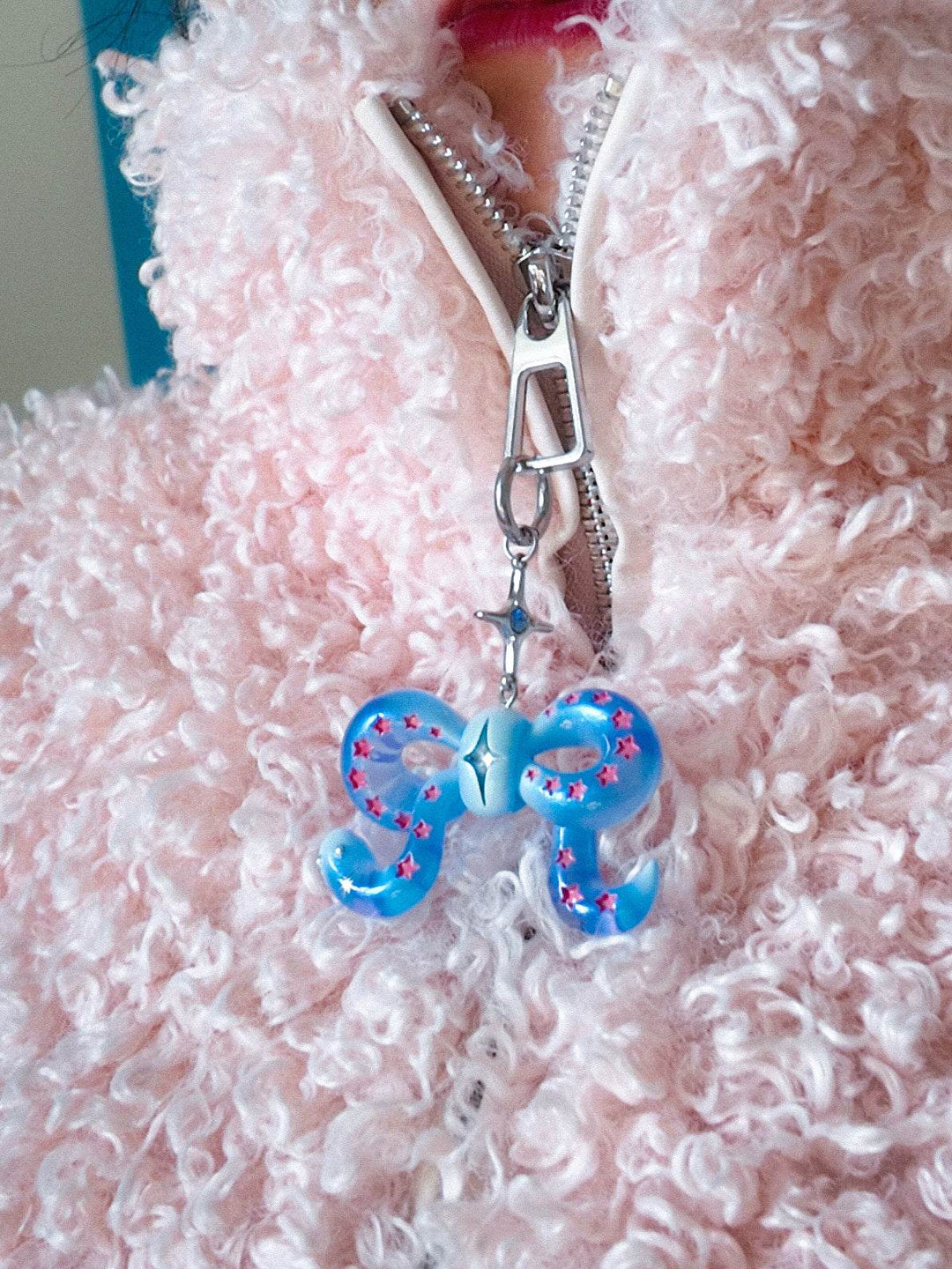 Ice blue snake bowtie necklace with pink stars and felt tongue on pink fuzzy jacket zipper