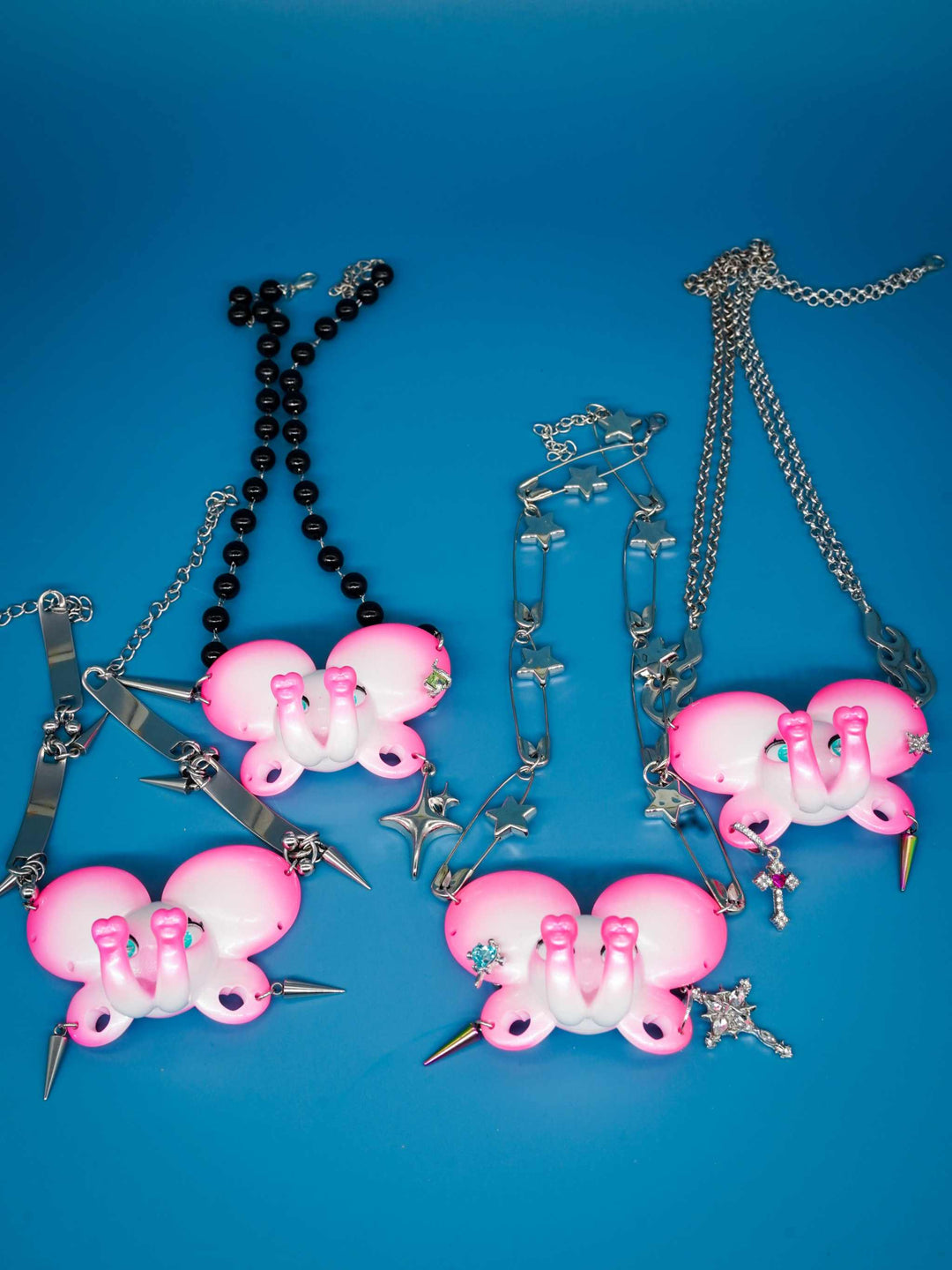 Twin-Trunk Diva Elephant Necklace in pink pearl white with two trunks, blue-green starry eyes, and customizable ear holes