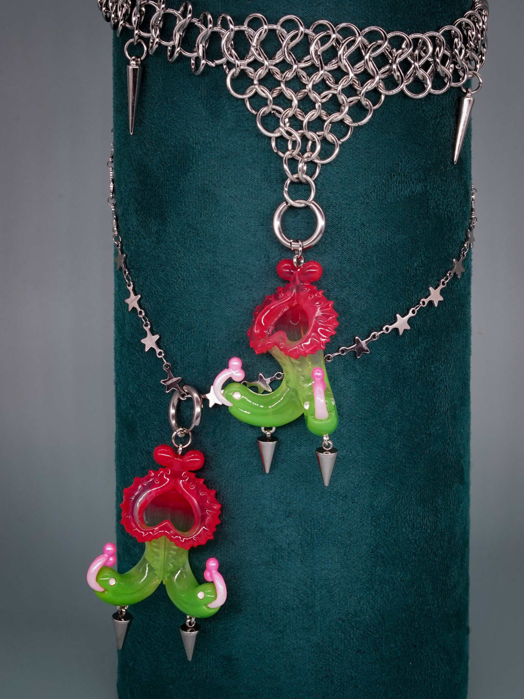 Twin-headed pitcher serpent earrings in translucent red, green, and pink with metallic spikes by Acid Candy
