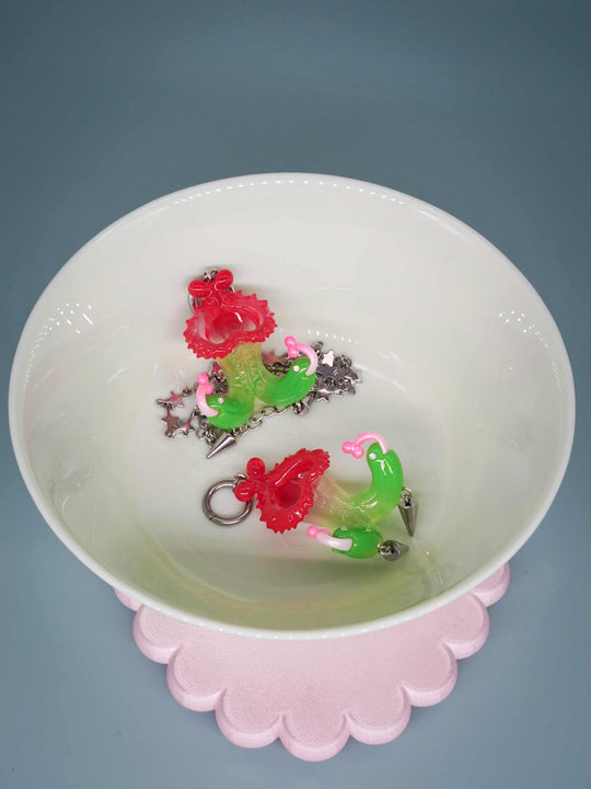 Twin-headed pitcher serpent earrings in translucent cherry red, acid green, and bubblegum pink with metal spikes by Acid Candy