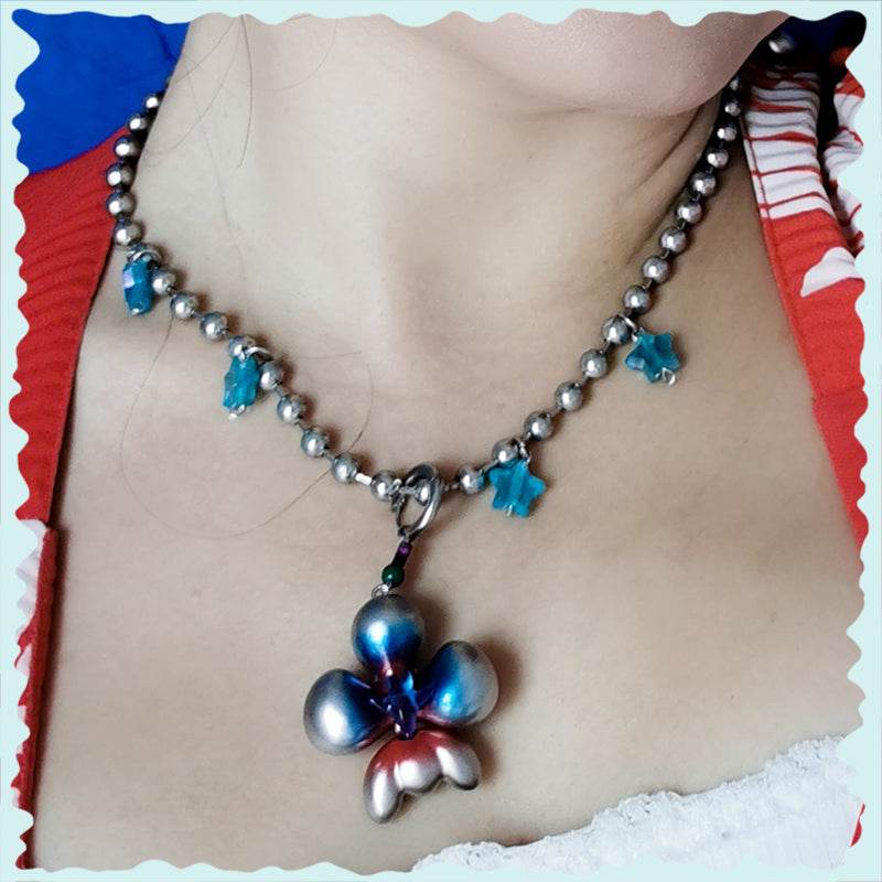 Cyber blue inflated butterfly orchid necklace with earrings on person, featuring blue and silver tones, polyurethane and titanium materials.