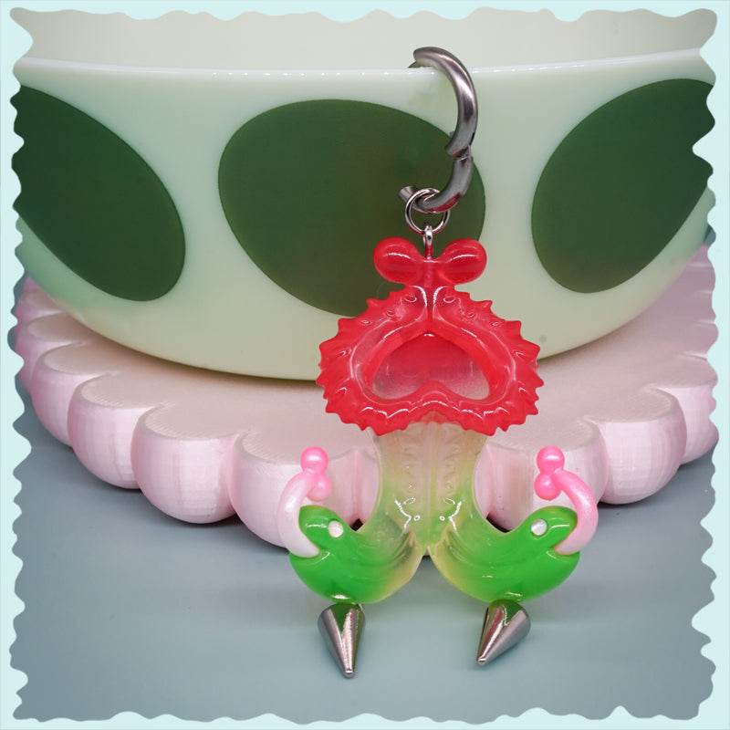 Twin-headed pitcher serpent earrings in translucent cherry red, acid green, and bubblegum pink with metal spikes and a pitcher-shaped body