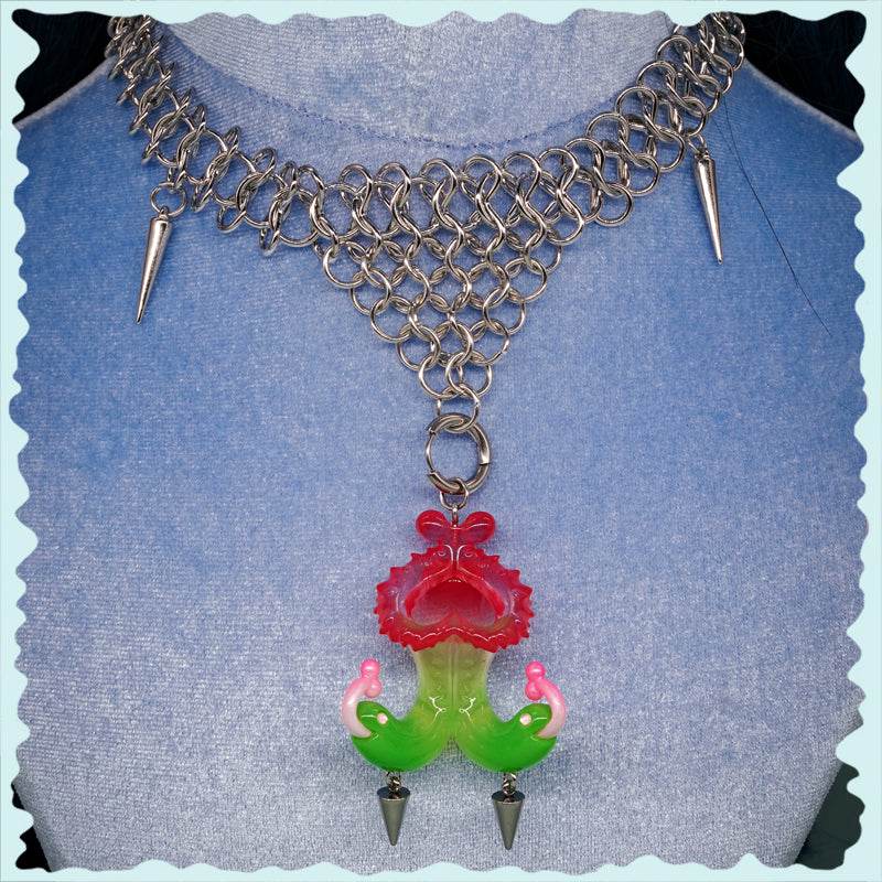Twin-headed pitcher serpent earrings in translucent red, green, and pink with metal spikes and serpent heads design
