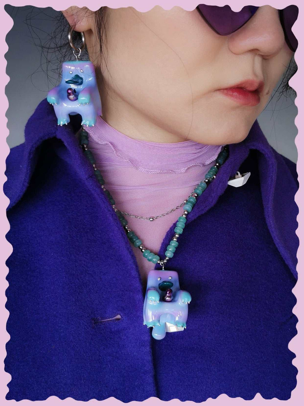Woman wearing purple rainbow platypus necklace and matching earrings with colorful beads